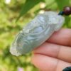 翡翠のペンダントを持つ手