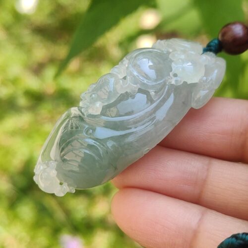 翡翠のペンダントを持つ手