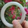 a hand holding a white circular ring