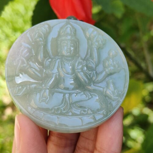Una mano sosteniendo un medallón de jade.