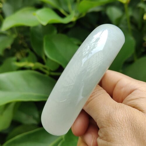 a hand holding a white bracelet