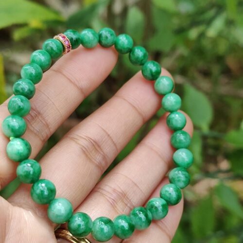 மணிகளால் ஆன வளையலை வைத்திருக்கும் ஒரு கை