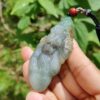 Una mano sosteniendo un colgante de jade.