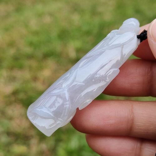 a hand holding a white jade object