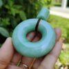 a hand holding a jade pendant