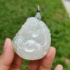 a hand holding a jade pendant