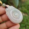 Una mano sosteniendo un colgante de jade.