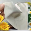 a hand holding a white napkin over yellow flowers