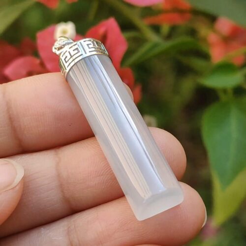 a hand holding a white crystal