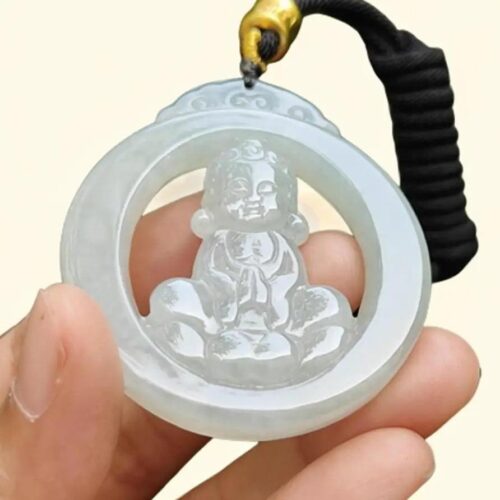 a hand holding a jade pendant
