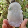 Una mano sosteniendo un colgante de jade.