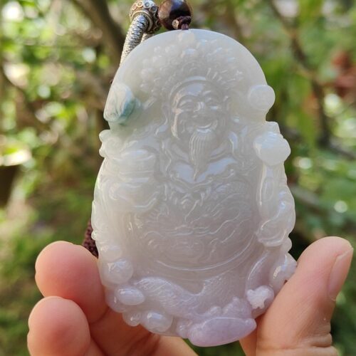 Una mano sosteniendo un colgante de jade.