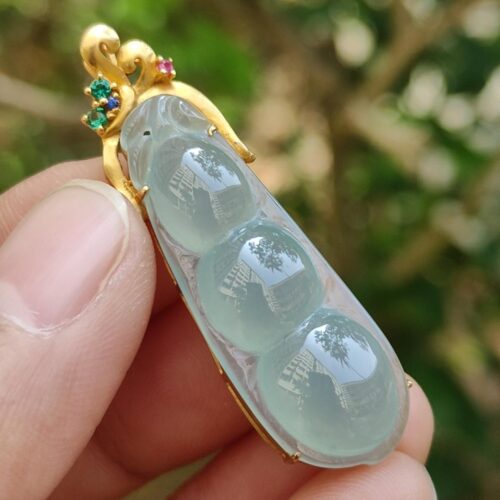 a hand holding a jade brooch