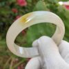 a hand in glove holding a white ring