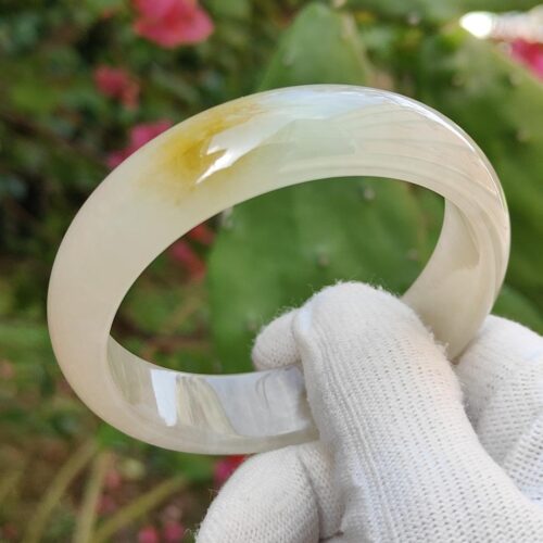a hand in glove holding a white ring