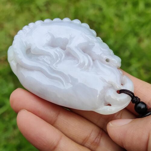 Una mano sosteniendo un colgante de jade.
