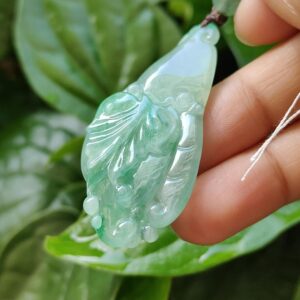 Una mano sosteniendo un colgante de jade.