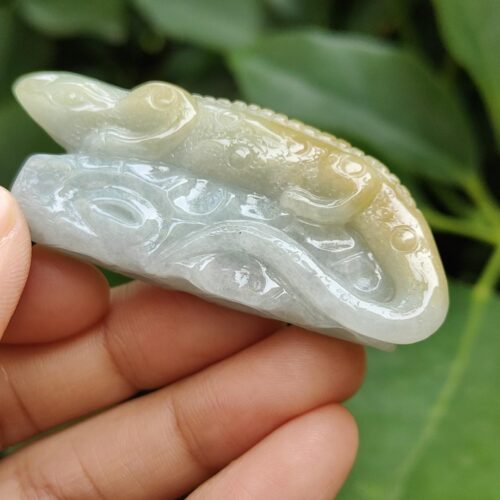 a hand holding a jade lizard