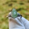 a ring with a green stone on it