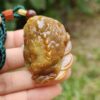 a hand holding a small frog shaped object