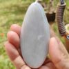 a hand holding a white stone