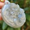Una mano sosteniendo un colgante de jade.