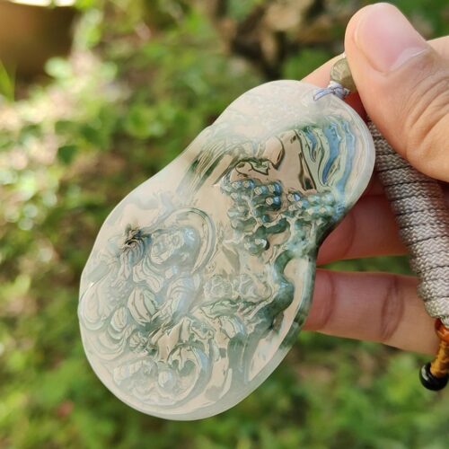 Una mano sosteniendo un colgante de piedra.