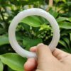 a hand holding a white circular object