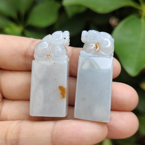 a hand holding two carved stone animals