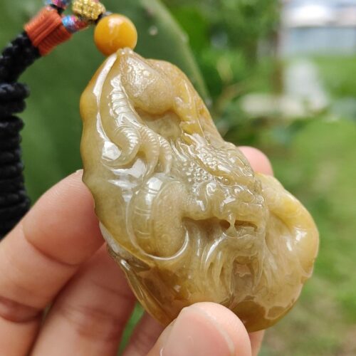 a hand holding a jade pendant