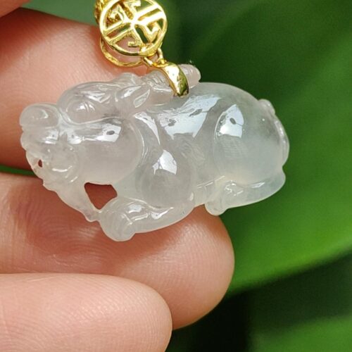 một bàn tay cầm một mặt dây chuyền ngọc bích