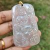 a hand holding a jade pendant