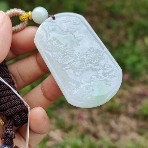 Una mano sosteniendo un colgante de jade.