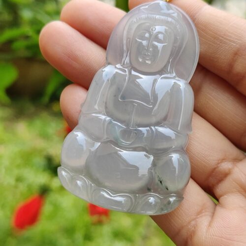 a hand holding a jade pendant
