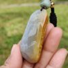 a hand holding a stone necklace
