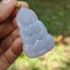 a hand holding a jade pendant