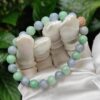 a hand wearing white gloves holding a bracelet