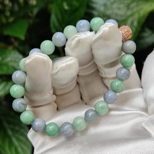 a hand wearing white gloves holding a bracelet