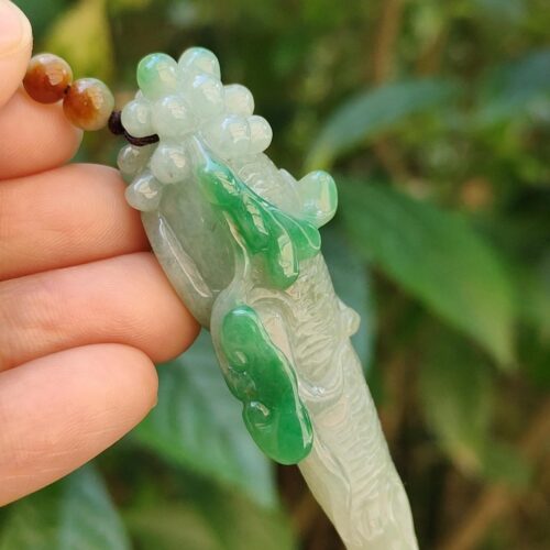 Una mano sosteniendo un colgante de jade.
