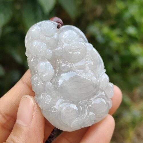 a hand holding a jade pendant