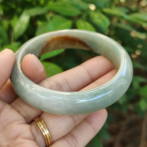 tangan memegang cincin giok