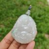 a hand holding a jade pendant