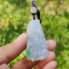 Una mano sosteniendo un colgante de jade.