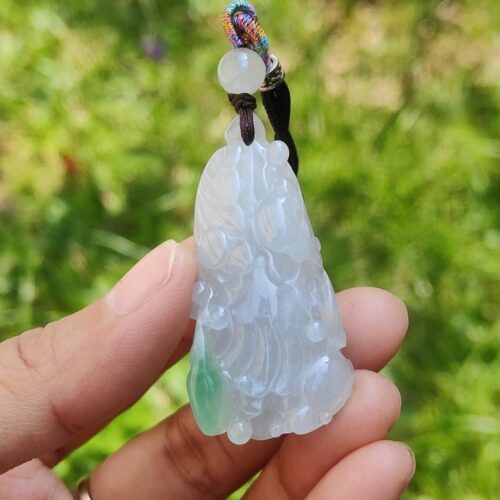 Una mano sosteniendo un colgante de jade.