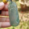 Una mano sosteniendo un colgante de jade.