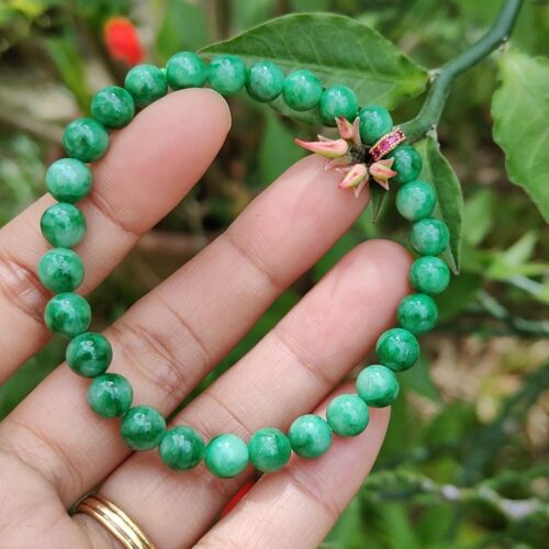 மணிகளால் ஆன வளையலை வைத்திருக்கும் ஒரு கை