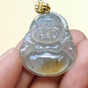 a hand holding a jade pendant