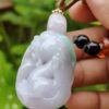a hand holding a jade pendant