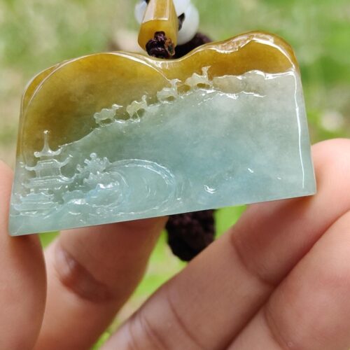 Una mano sosteniendo un colgante de jade.