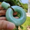 a hand holding a jade necklace